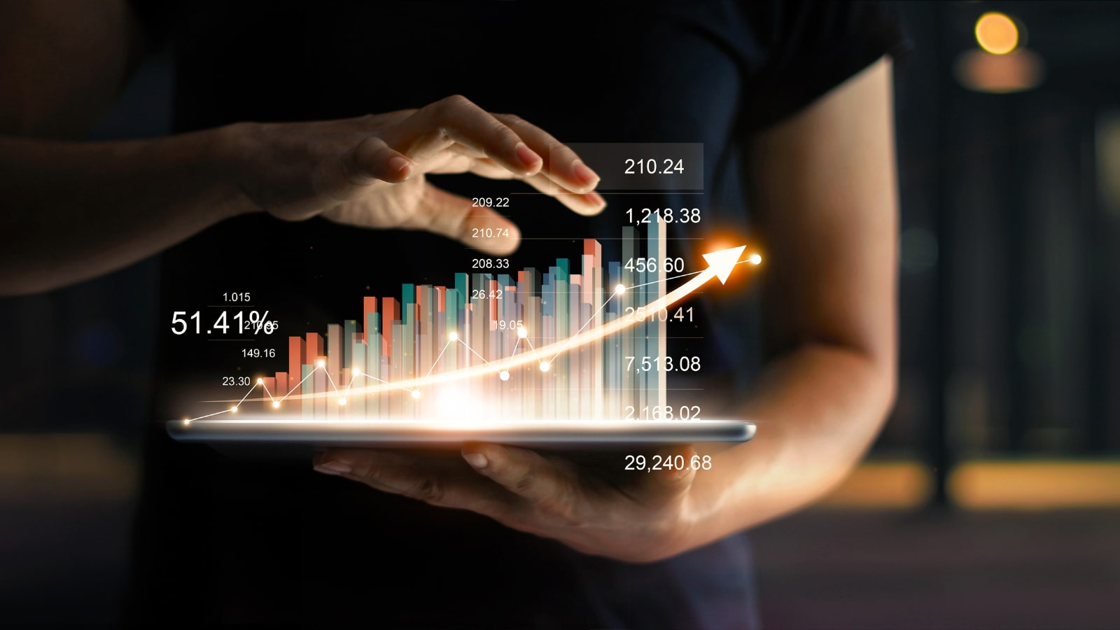 Businessman holding tablet and showing a glowing hologram of statistics indicating growth.
