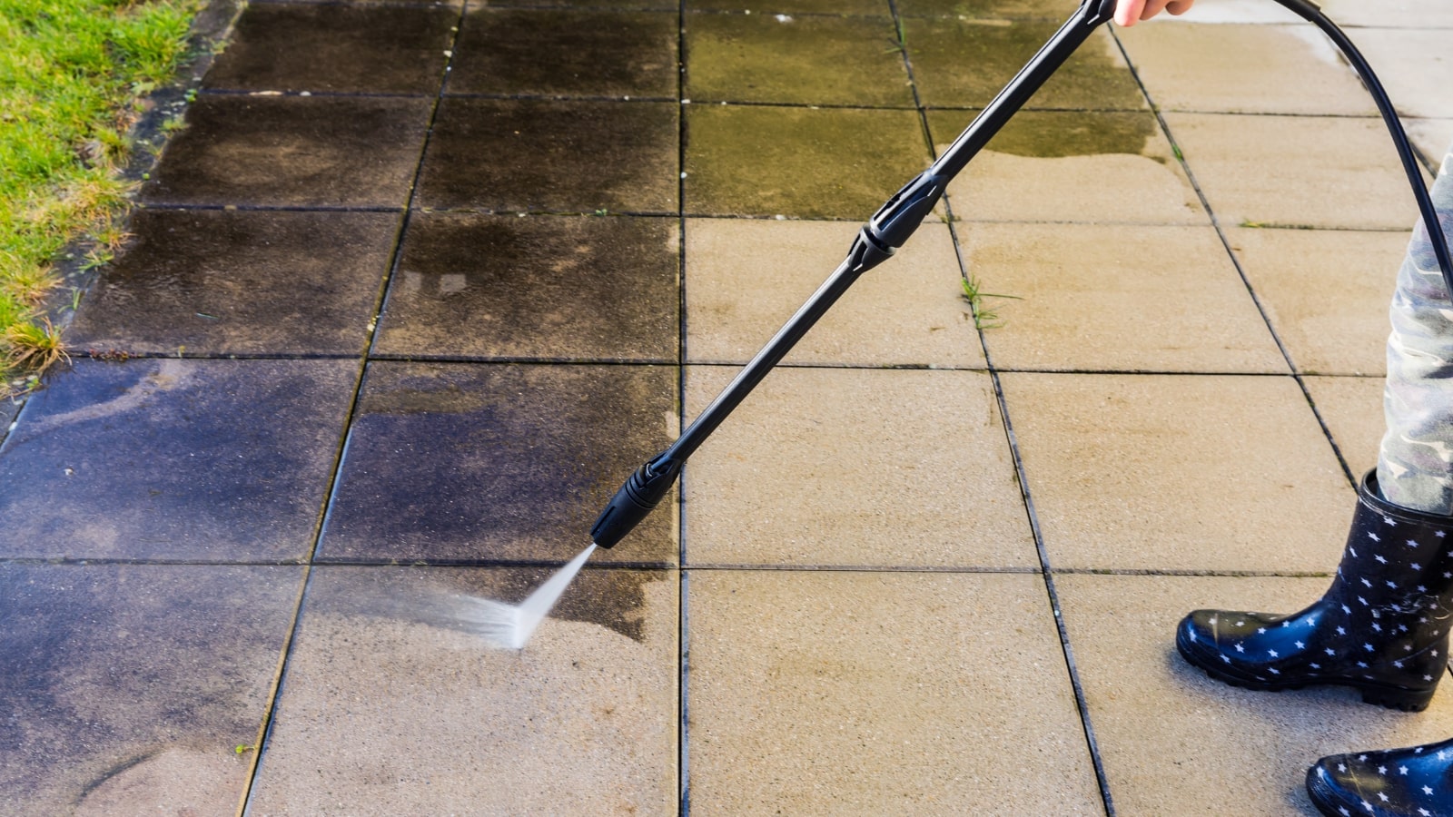 Cleaning terrace with high-pressure water blaster.
