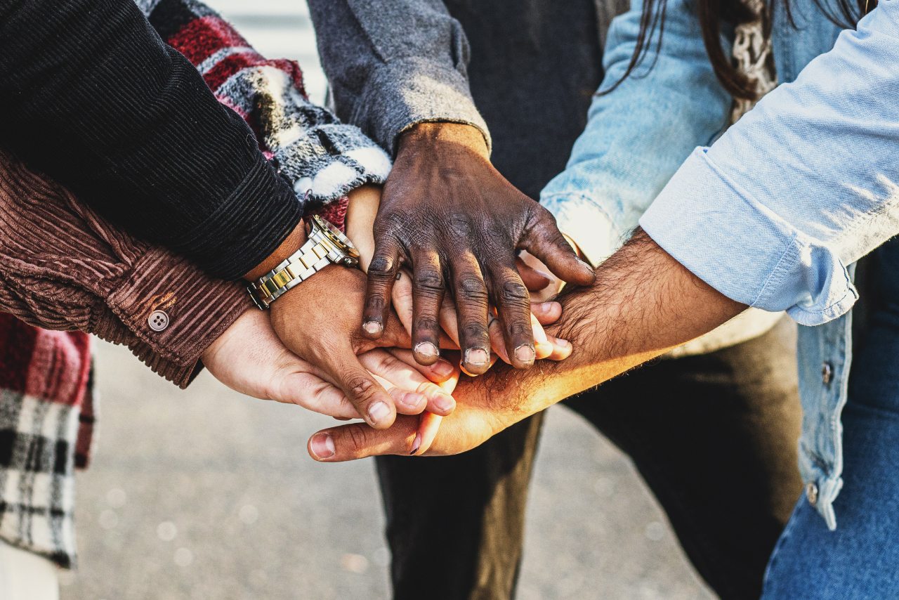 Different people's hands coming together to form a community.