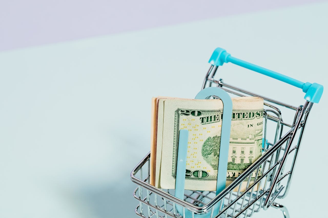 Dollar bills placed inside a miniature shopping cart