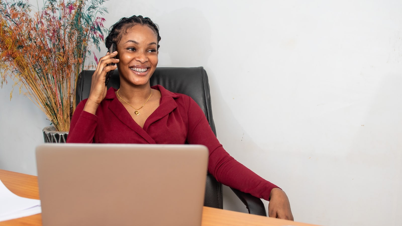 Female business owner excitedly announcing new product to affiliates via phone.