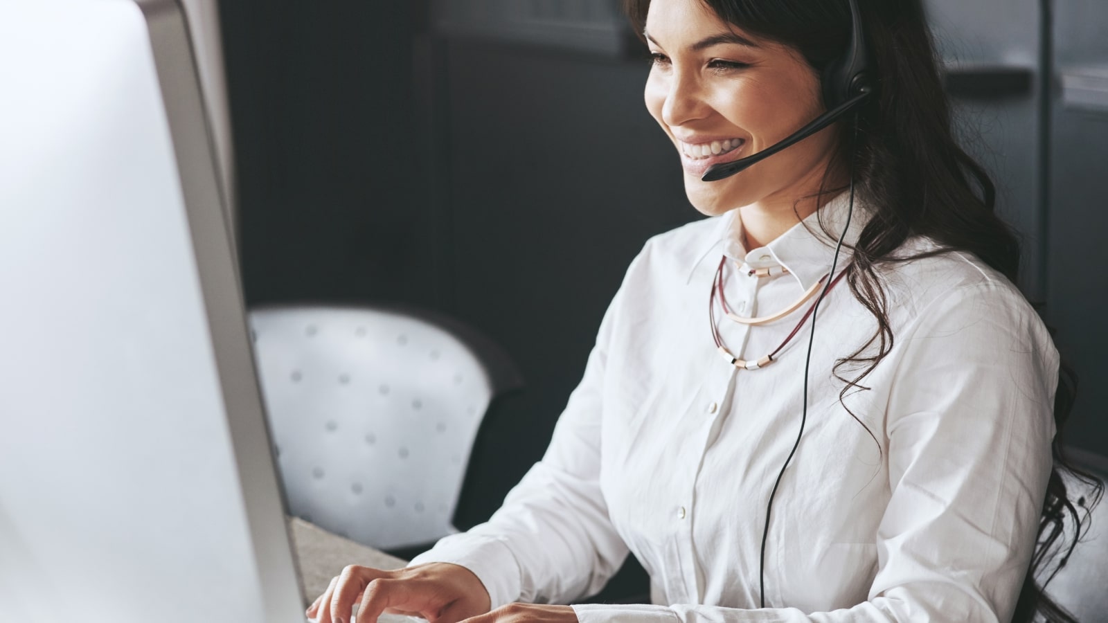 Female business owner happily responds to affiliate questions via chat and phone.