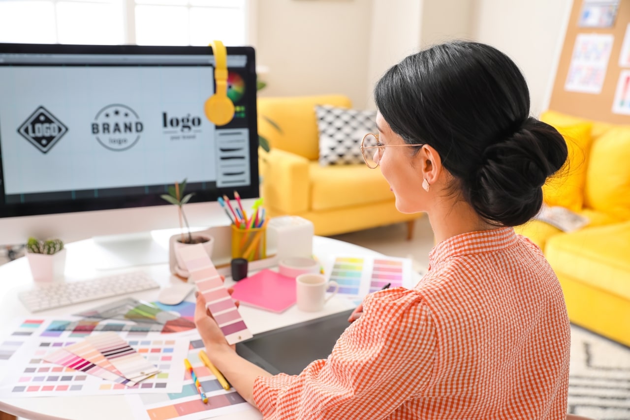 Female graphic artist working on a logo on work desk.