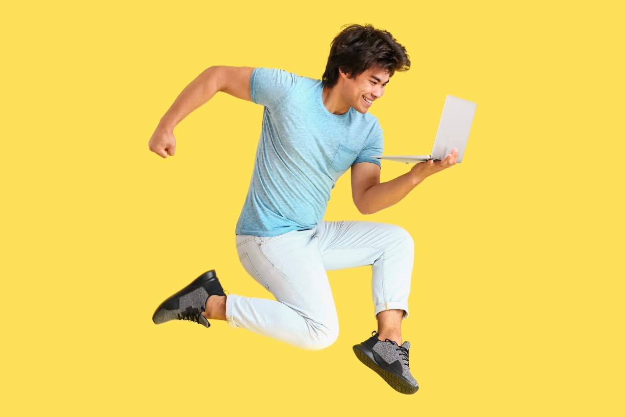 Jumping Male Programmer with Laptop on Yellow Background.