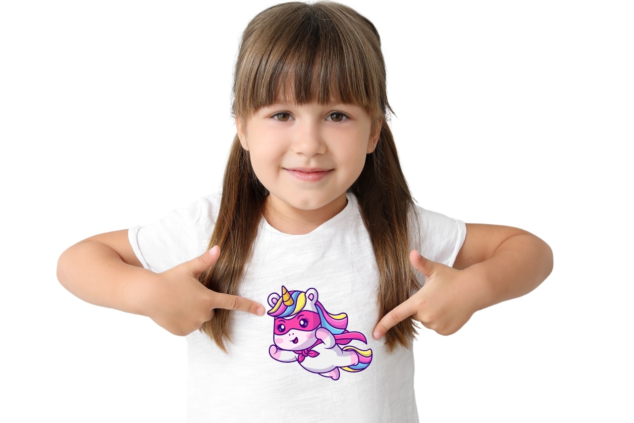 Little girl pointing at her tshirt's unicorn logo.