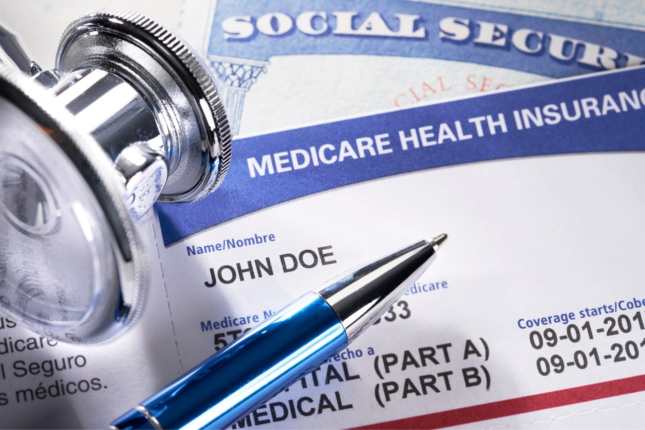 Medicare Health Insurance and Social Security card with stethoscope and pen.