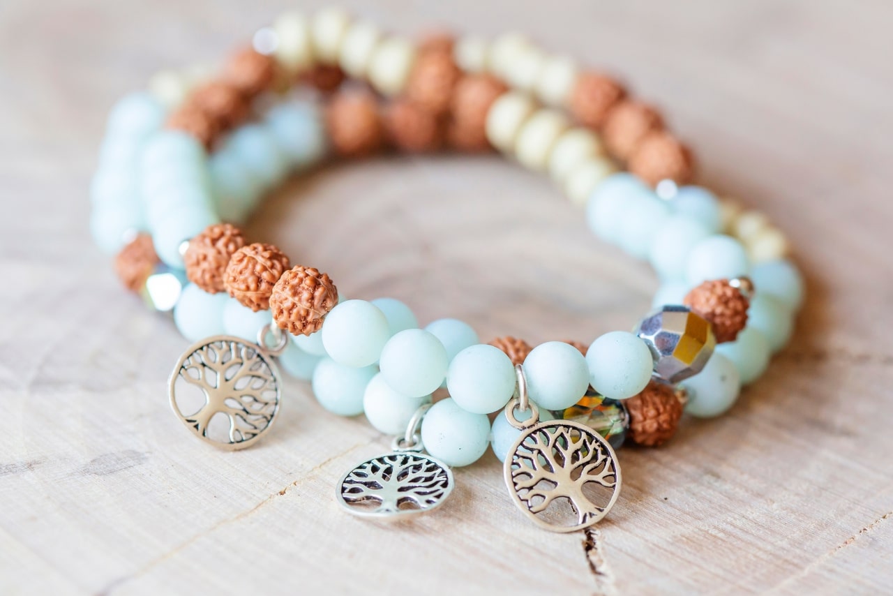 Mineral stone amazonite and tree pendant bracelet on wooden background.