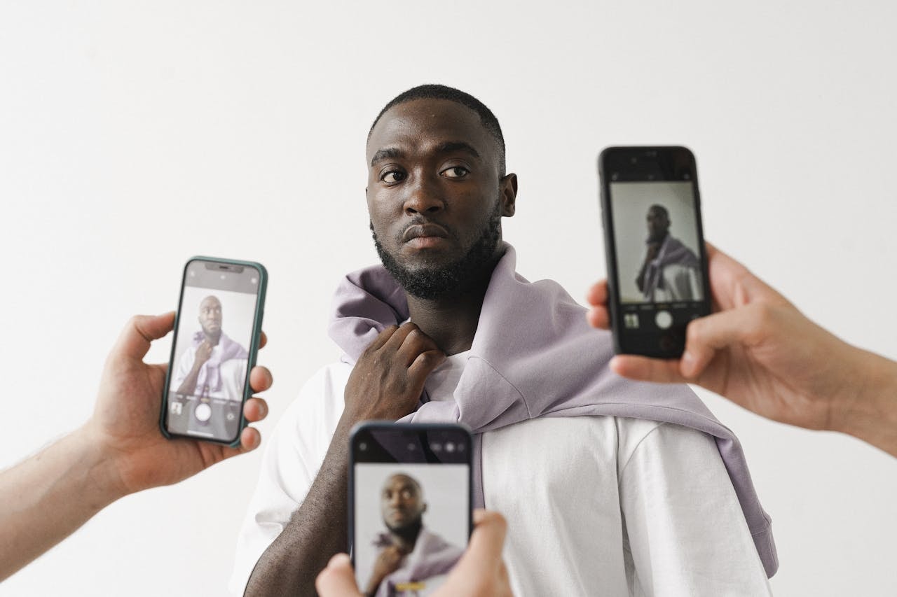 People taking pictures of a fashion model in different angles using mobile phones
