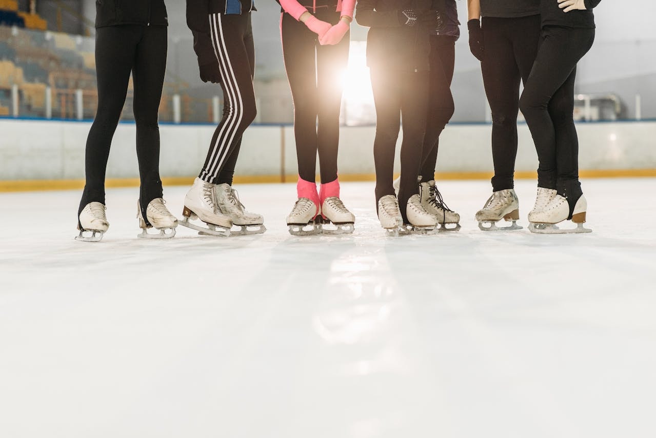 People wearing ice skates on an ice skating rink