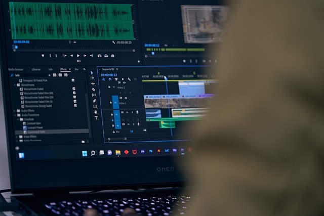 Person editing video content on laptop.