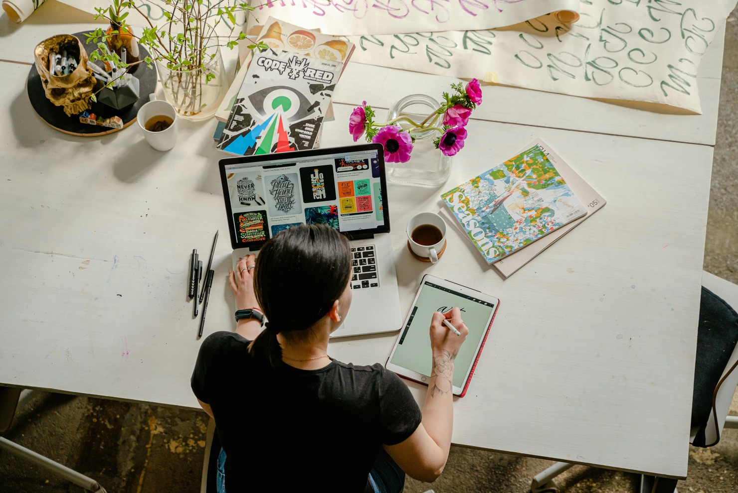 Photo of Woman Writing on Tablet Computer While Using Laptop.