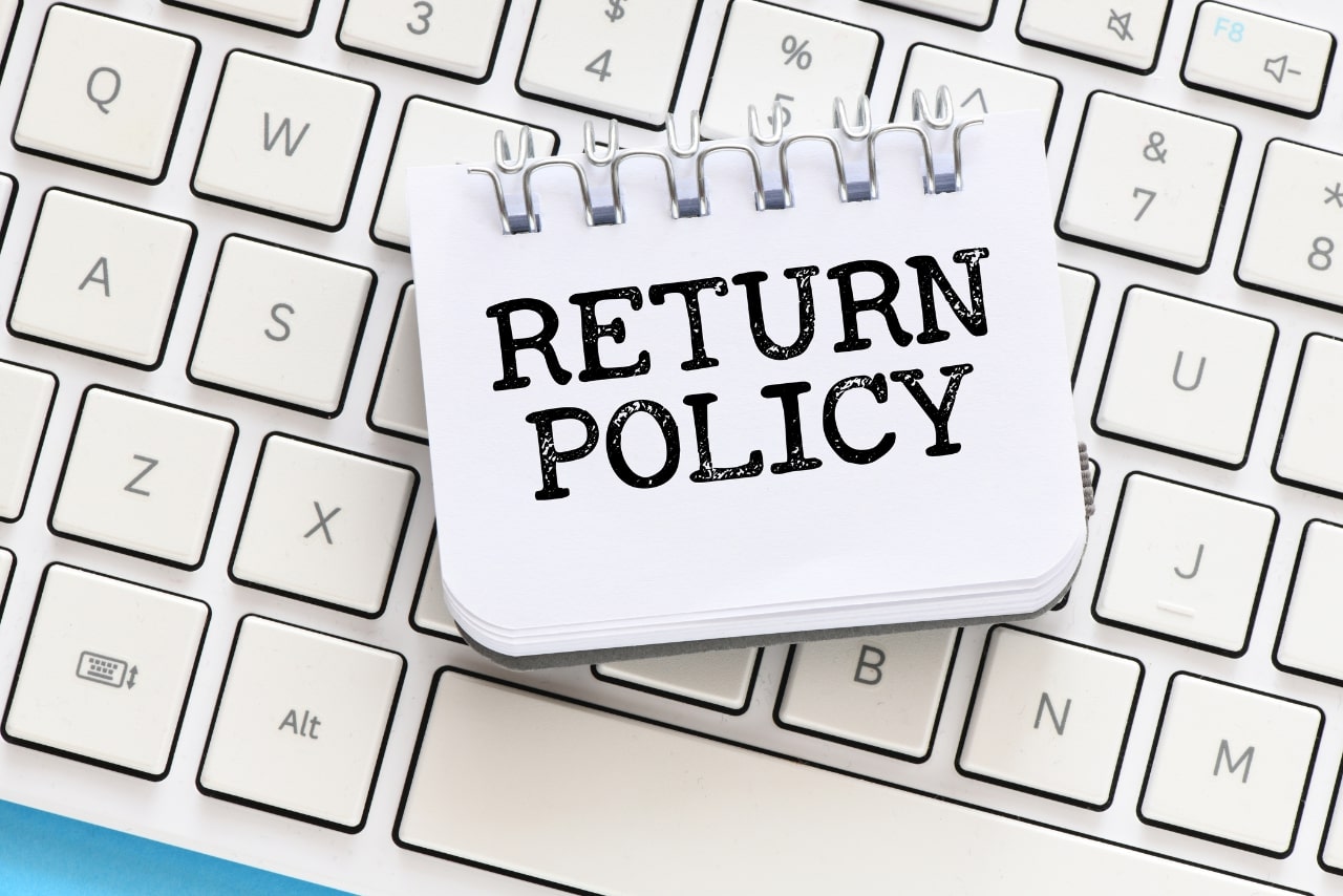 RETURN POLICY word in an office notebook.