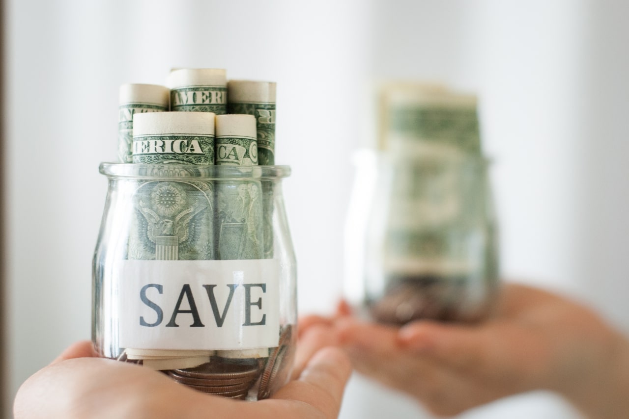 Saving money inside a jar glass.