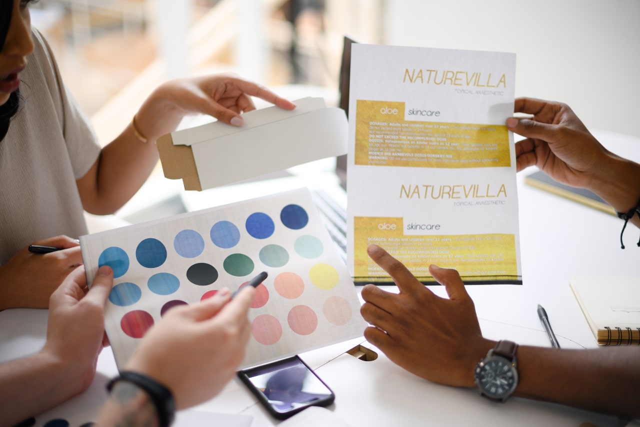 Shot of a group of businesspeople going through paperwork and colourwheel to build brand.