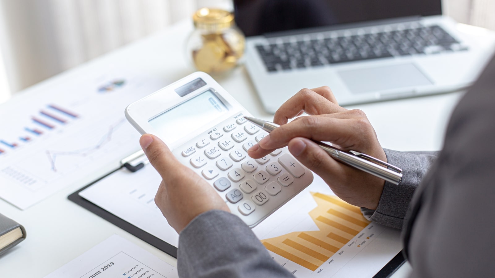 Side view of a person calculating and analyzing business finances.