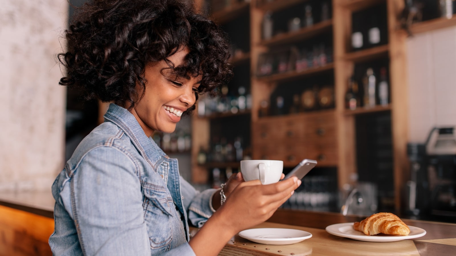 Smiling Woman while watching video content on her Smart Phone.