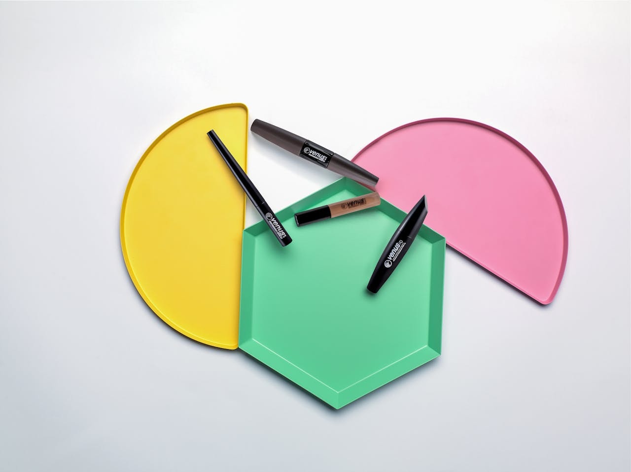 Top-down photo of eye makeup products using a colorful background