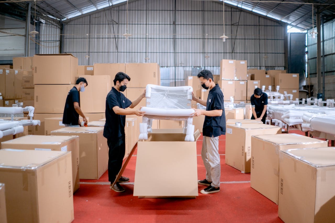 Two men in a furniture factory putting a chair in a box