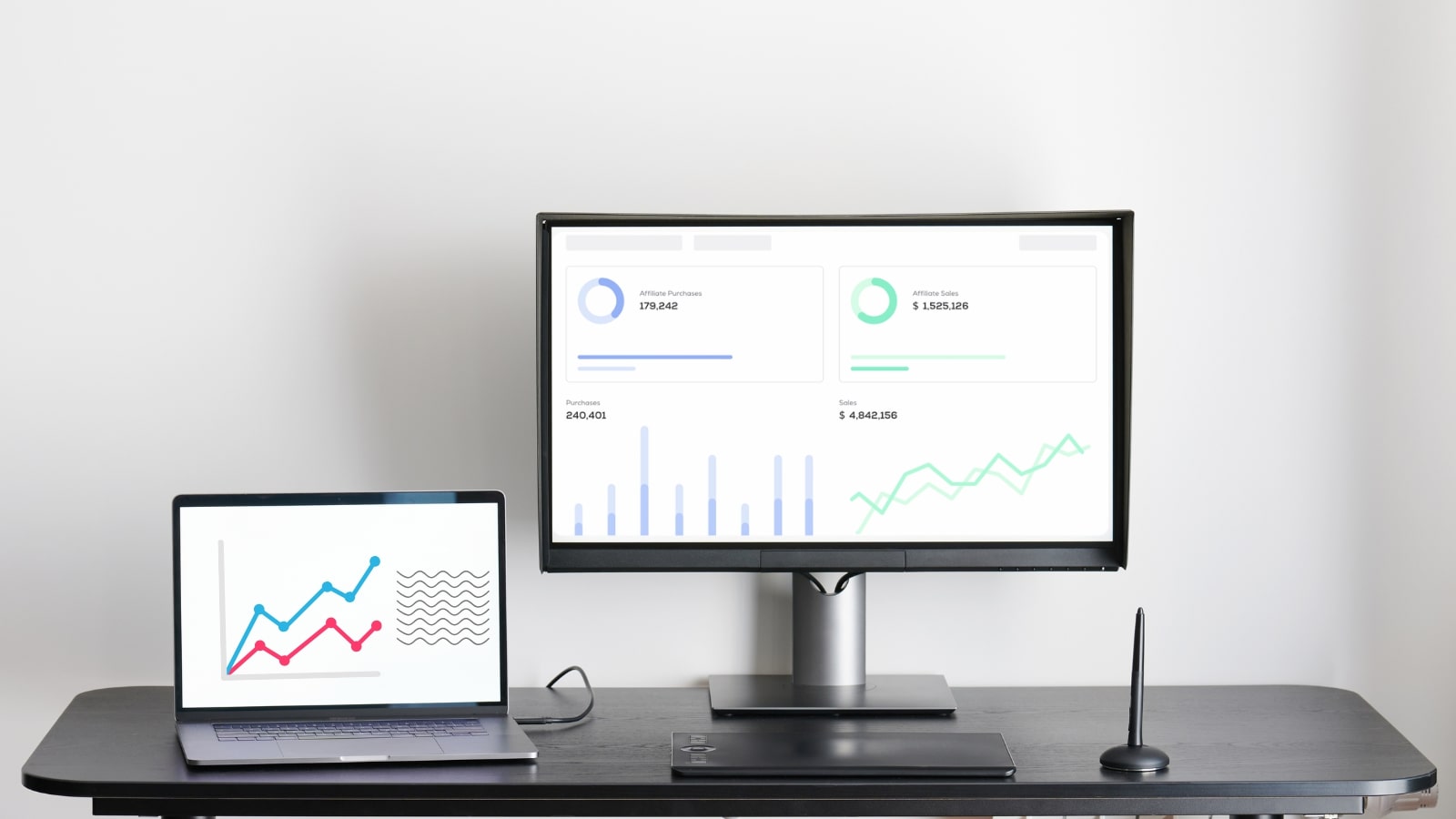 Two monitor screens showing affiliate program tracking performance.