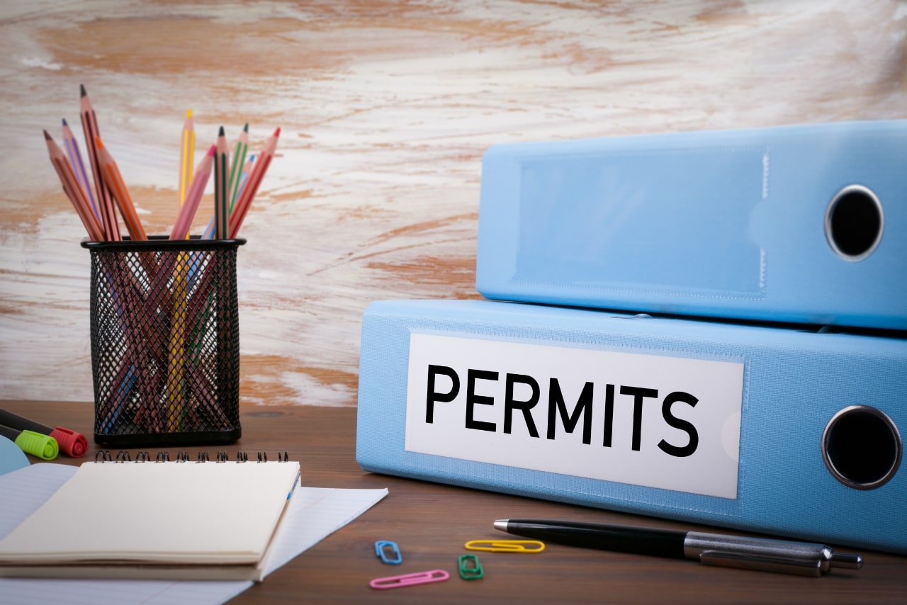 Two stack of folders containing permits.
