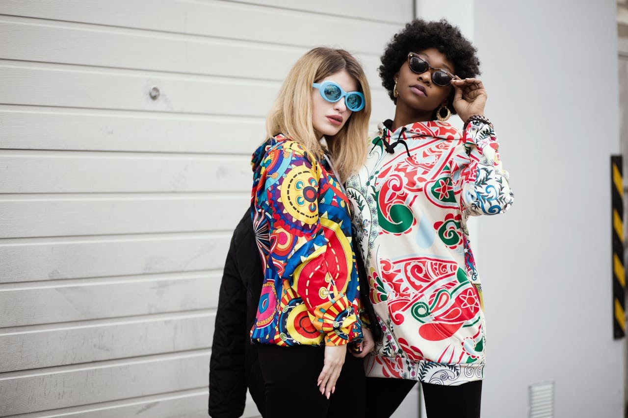 Two women wearing printed hoodies
