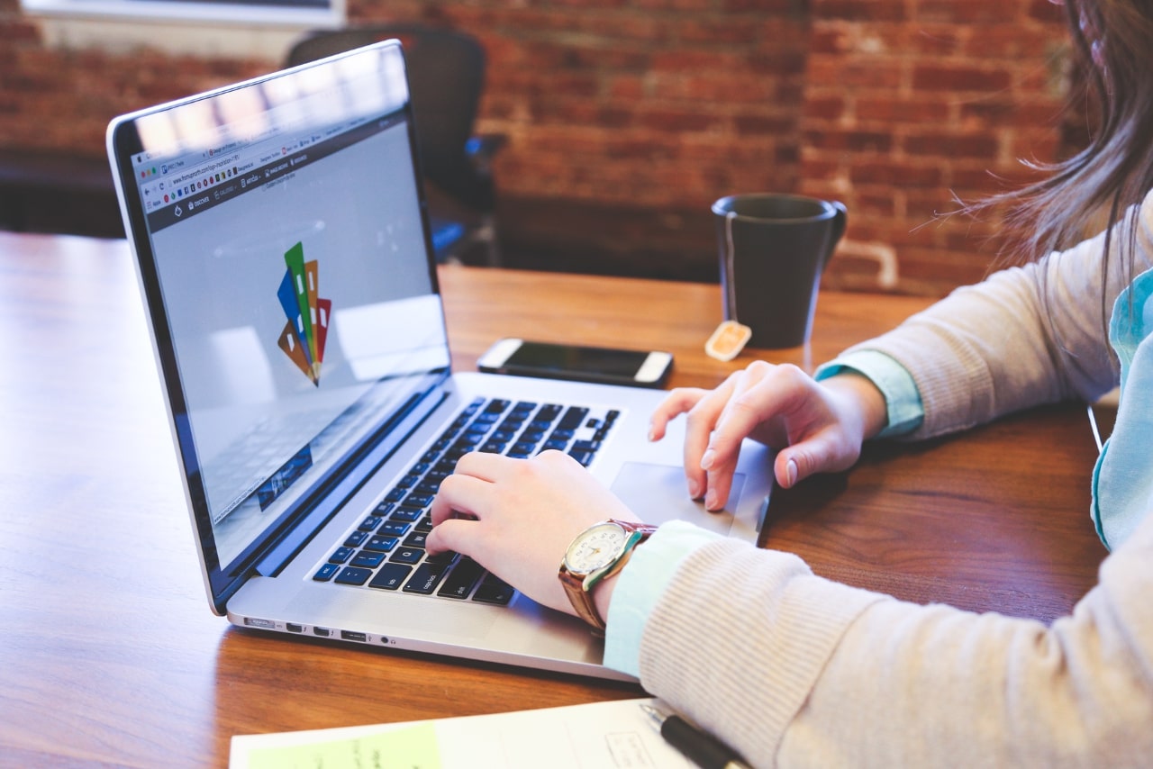 Woman creating logo on laptop.