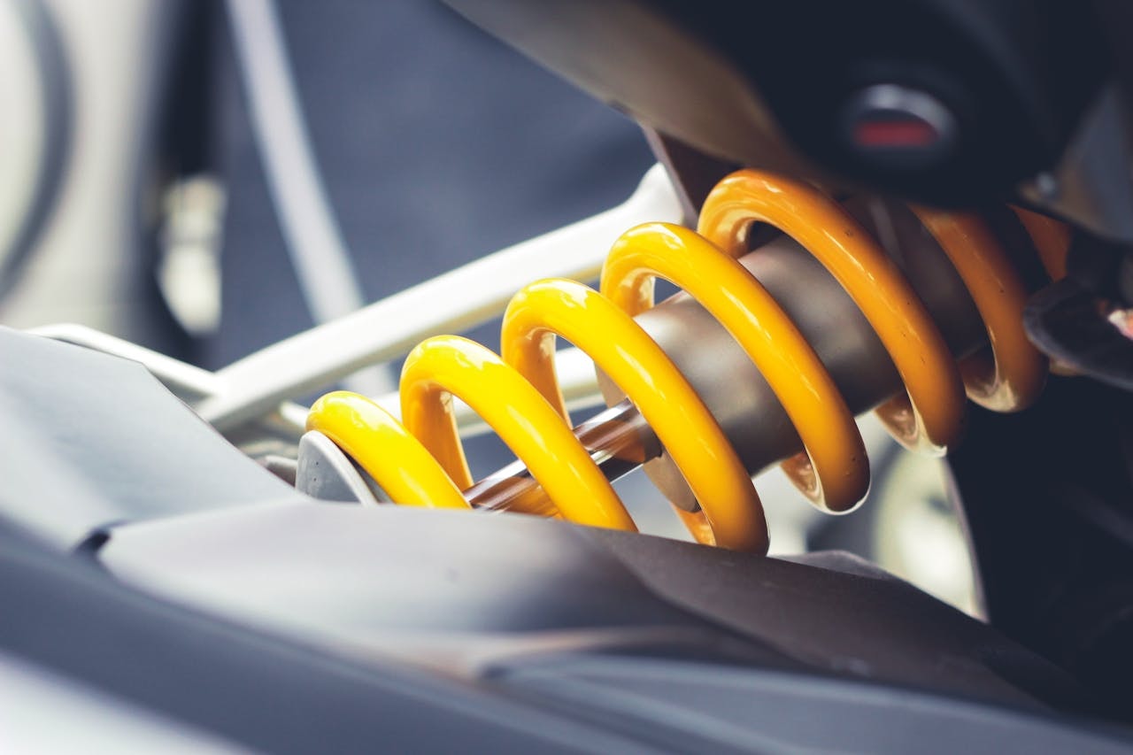 A close-up photo of a car suspension painted in yellow