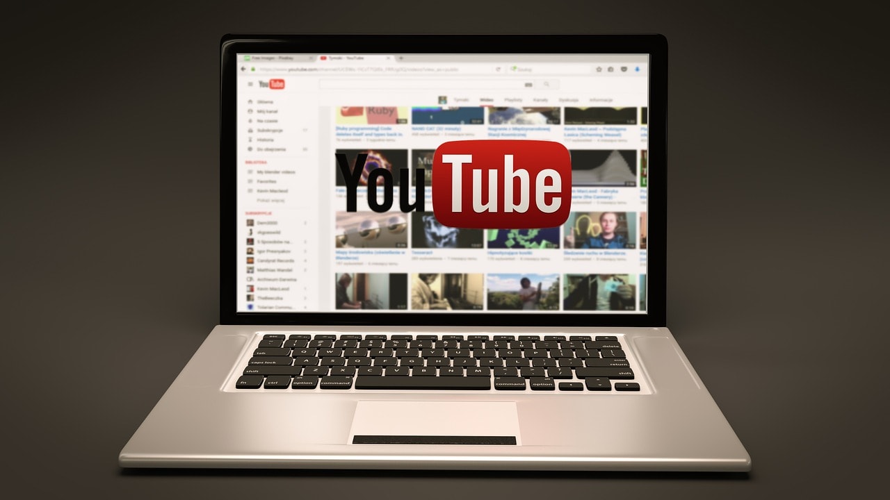 A laptop displaying the YouTube website and showing various video thumbnails