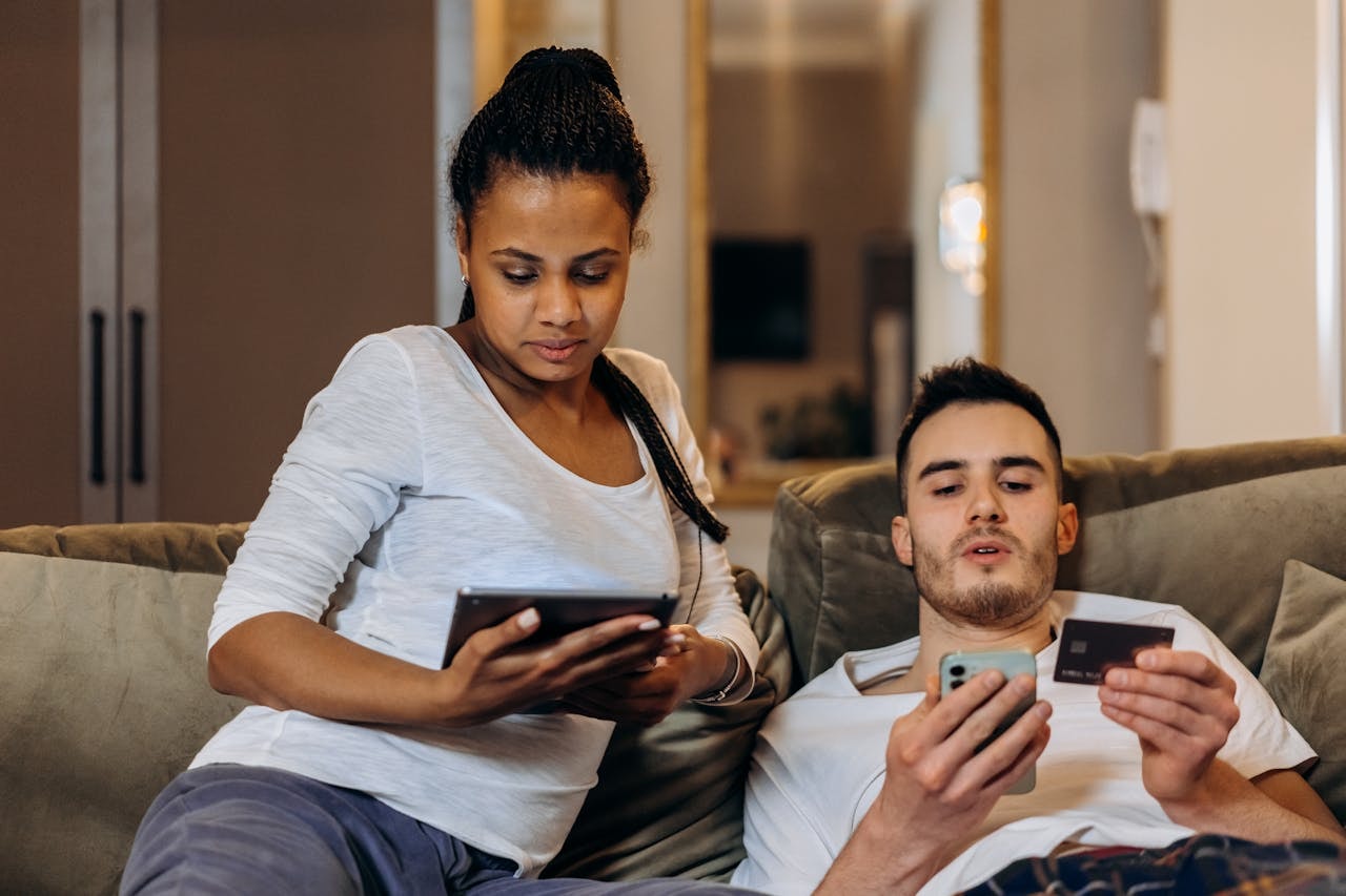 A man and a woman shopping online on mobile devices
