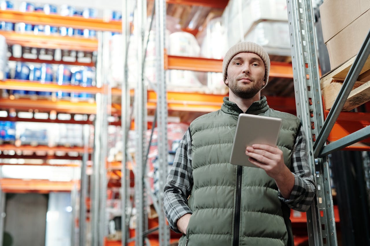 A man holding a tablet computer at a warehouse