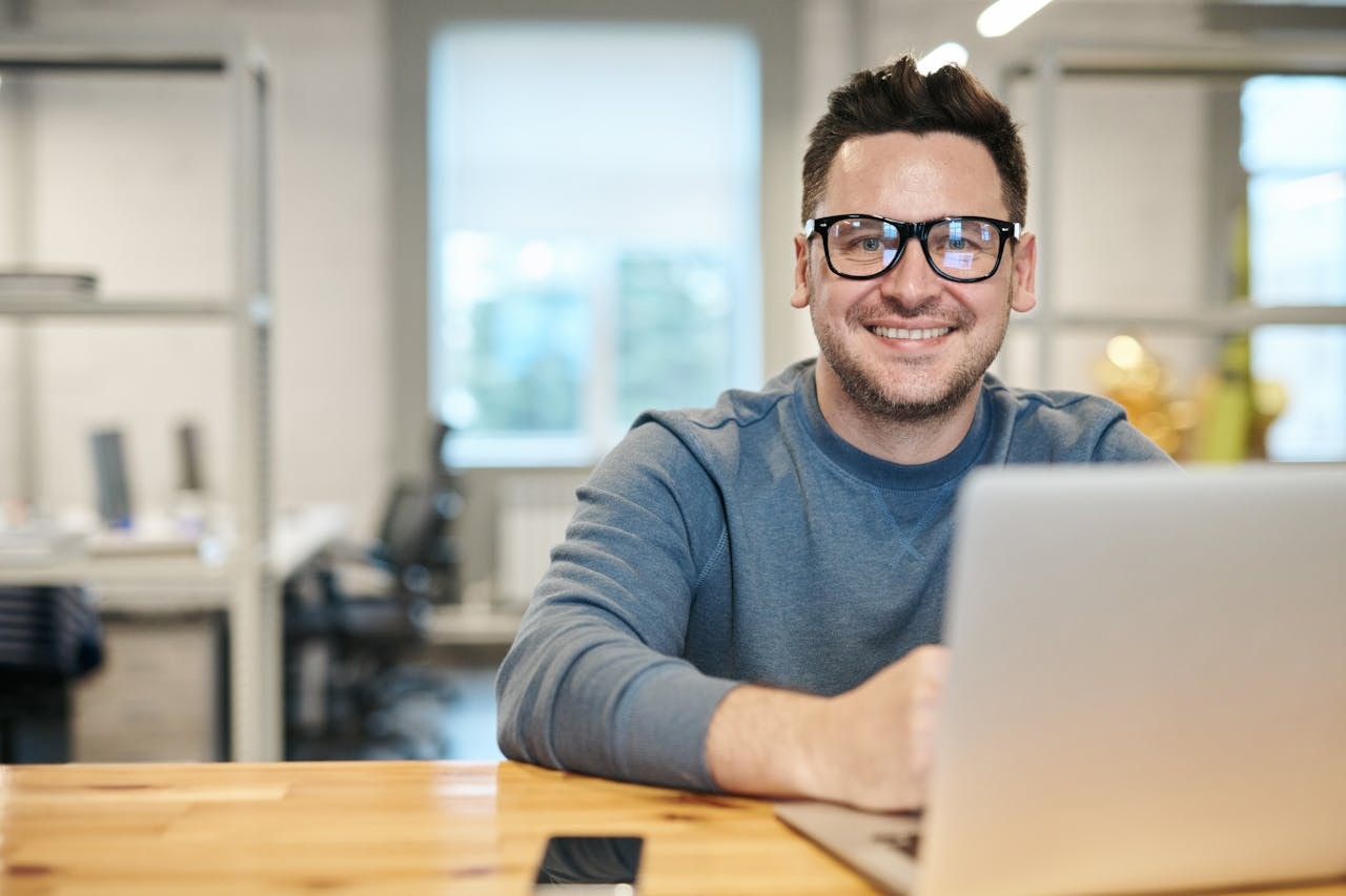 A man on his desk smiling brightly