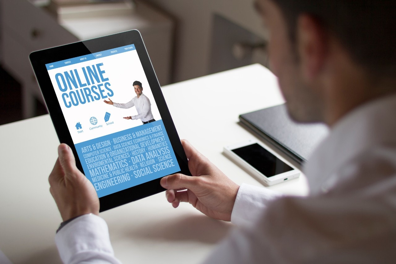 A man taking an online course on his tablet.