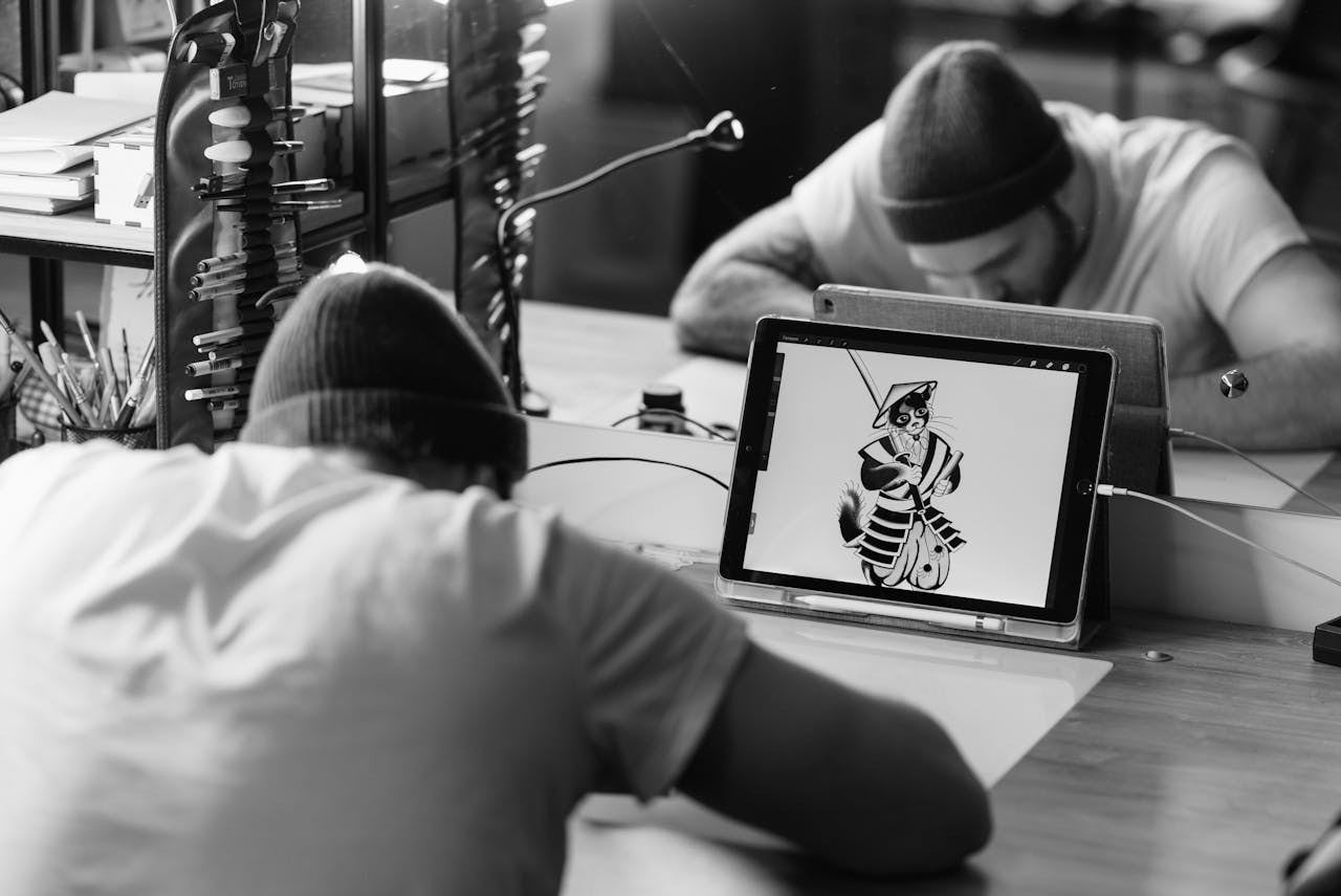 A man working at a table with digital artwork in front of him