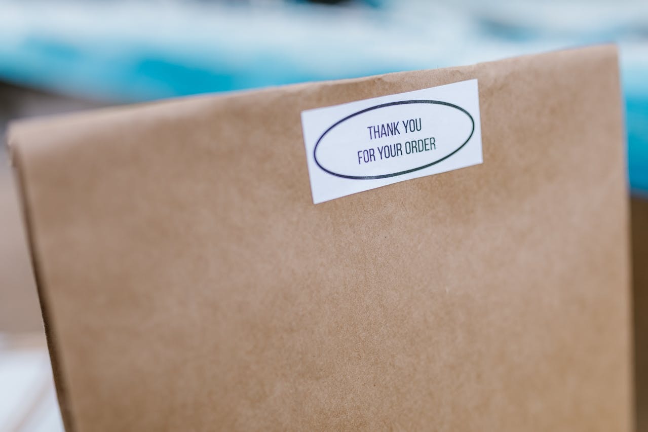 A paper bag with a sticker Thank you for your order
