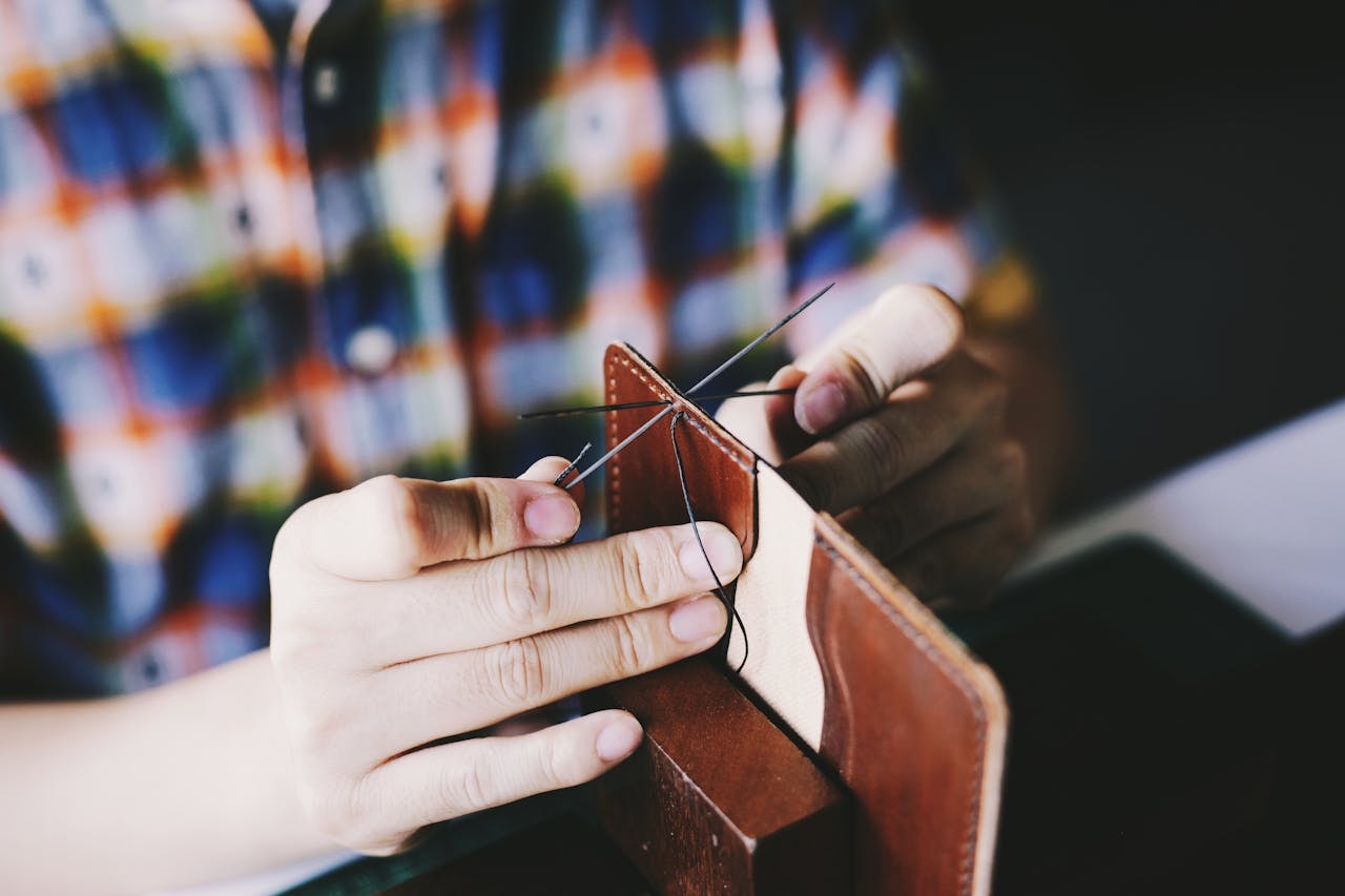 A person knitting brown leather textile