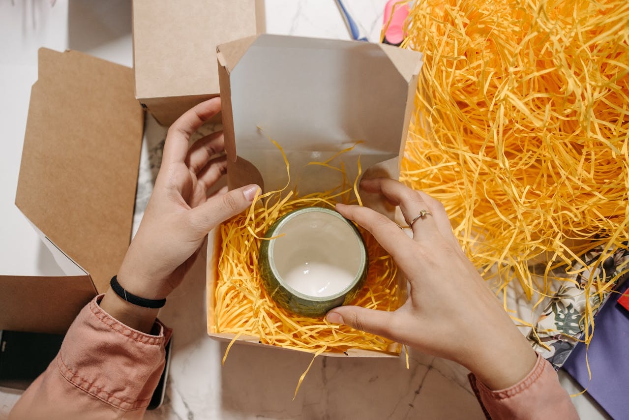 A person packing a ceramic item into a box that fits perfectly