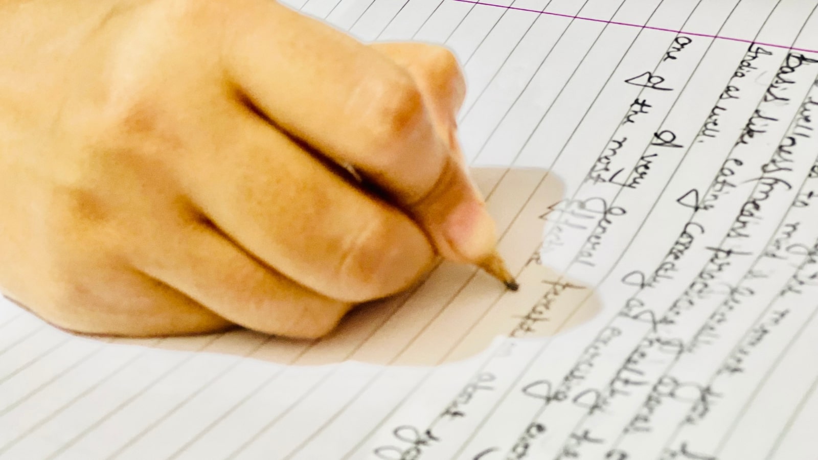 A person writing a long article on notebook.
