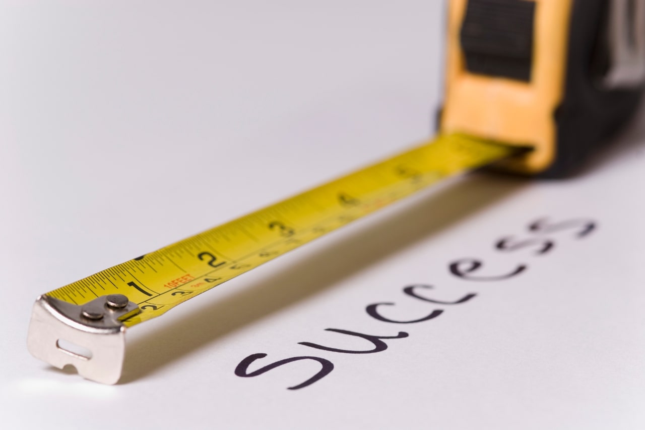 A steel tape measuring the word success.