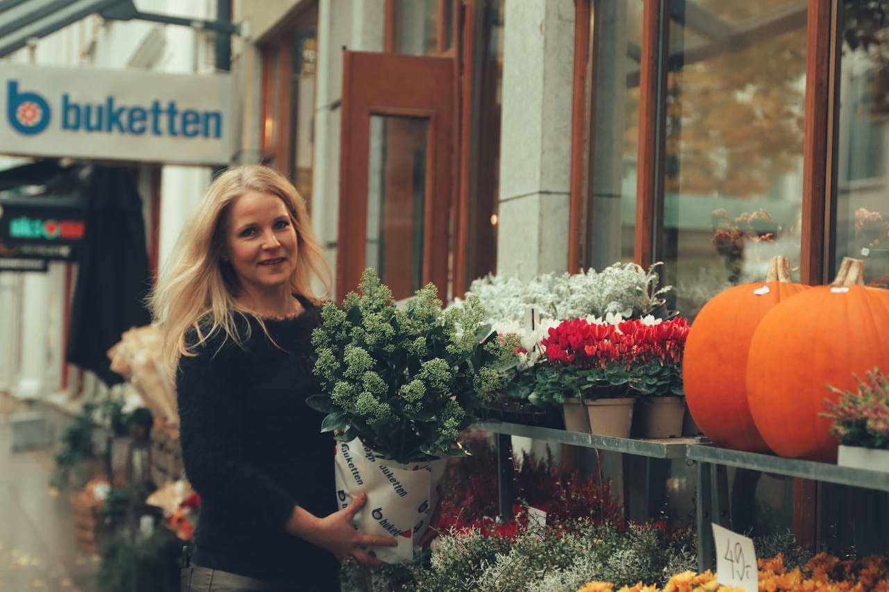 A woman holding a plant wrapped in paper