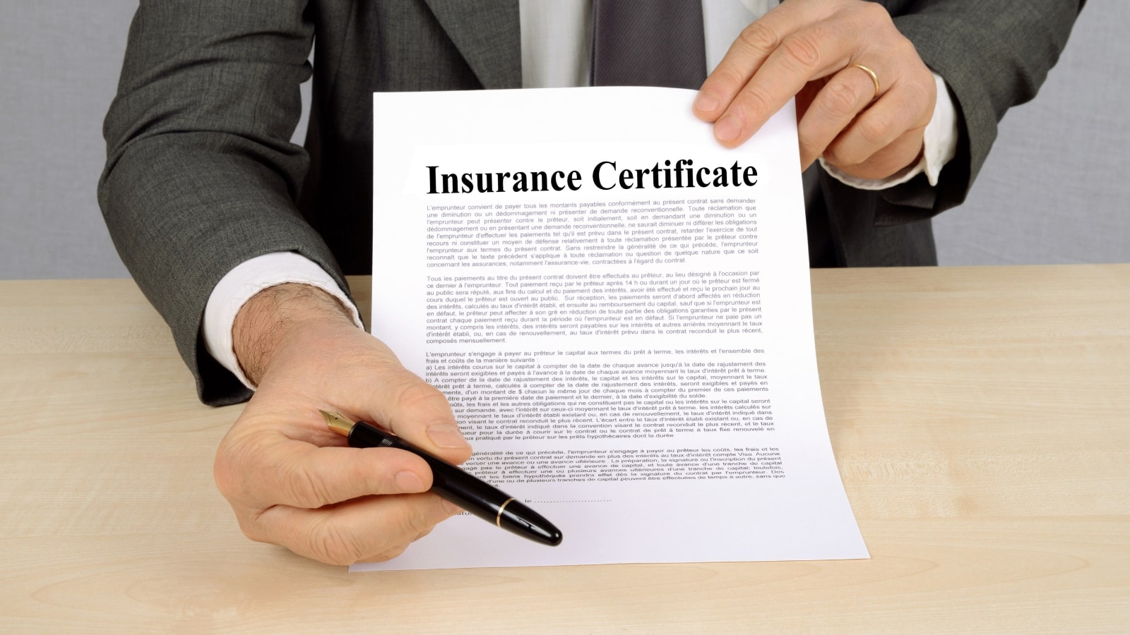 Agent presenting certificate insurance and pen for signature.