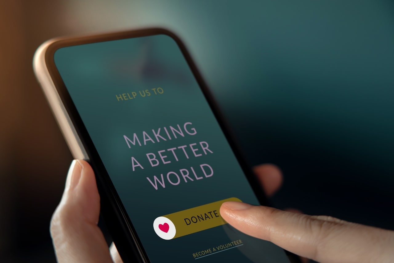 Close up image of person donating reward points to charity through smartphone.