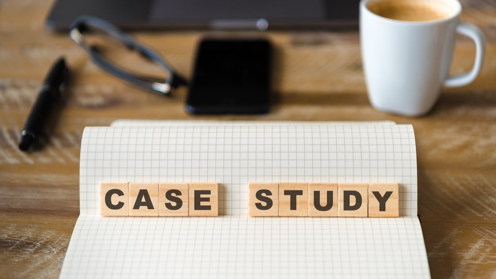 Closeup on notebook with wooden blocks with letters making Case Study text.