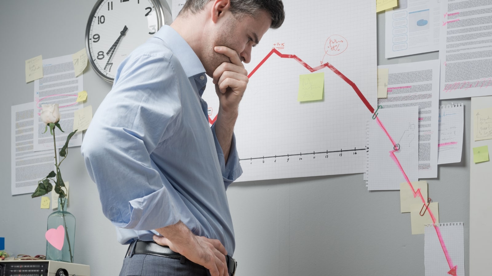 Concerned businessman looking at negative business chart but learning from failures.
