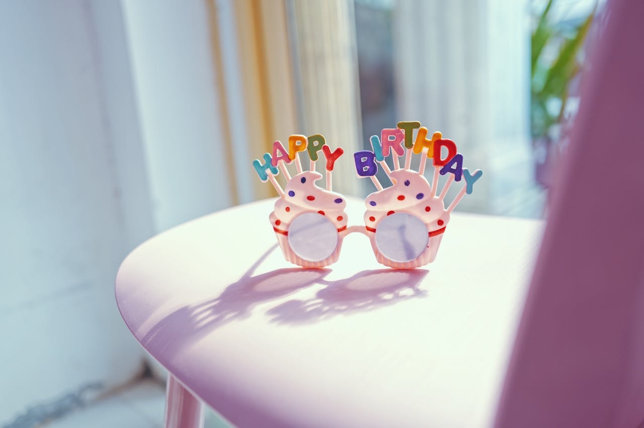 Cupcake-shaped sunglasses with colorful Happy Birthday text on top of the lens