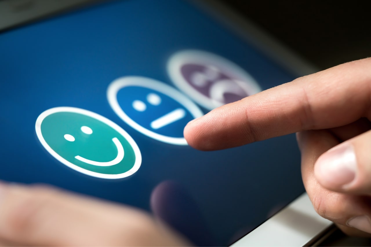 Customer choosing happy emoji icon to give customer service feedback.