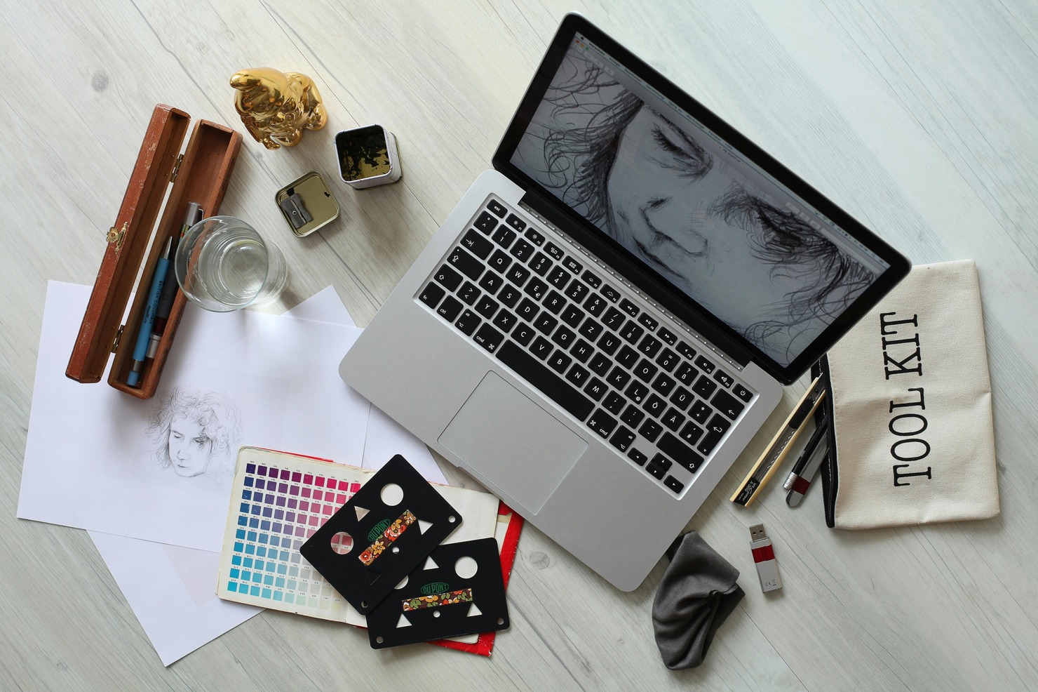 Desk setup with laptop and graphic design tools.