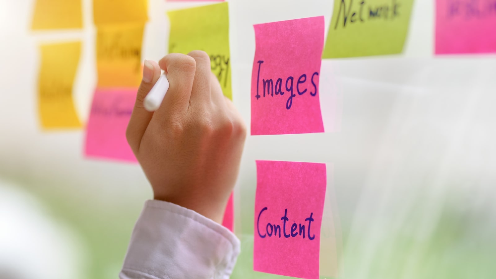 Female Content Creator planning content using sticky notes.