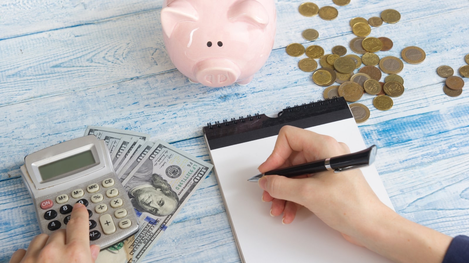 Female using calculator to create budget from own money and savings.