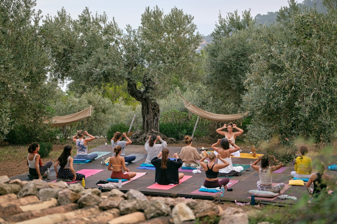 Group of women sittinmg on mats doing yoga.