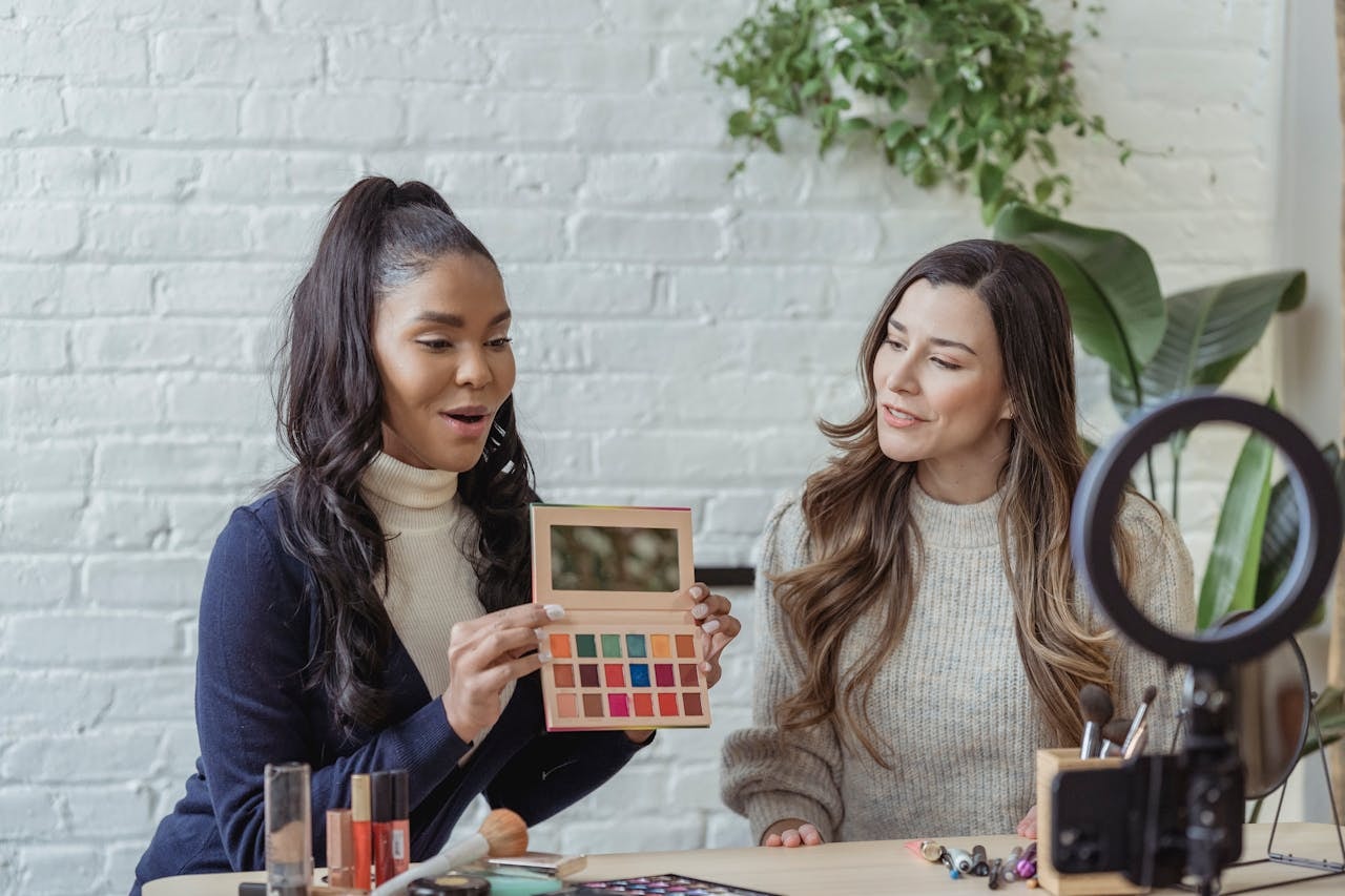 Ladies recording vlog about makeup products on smartphone